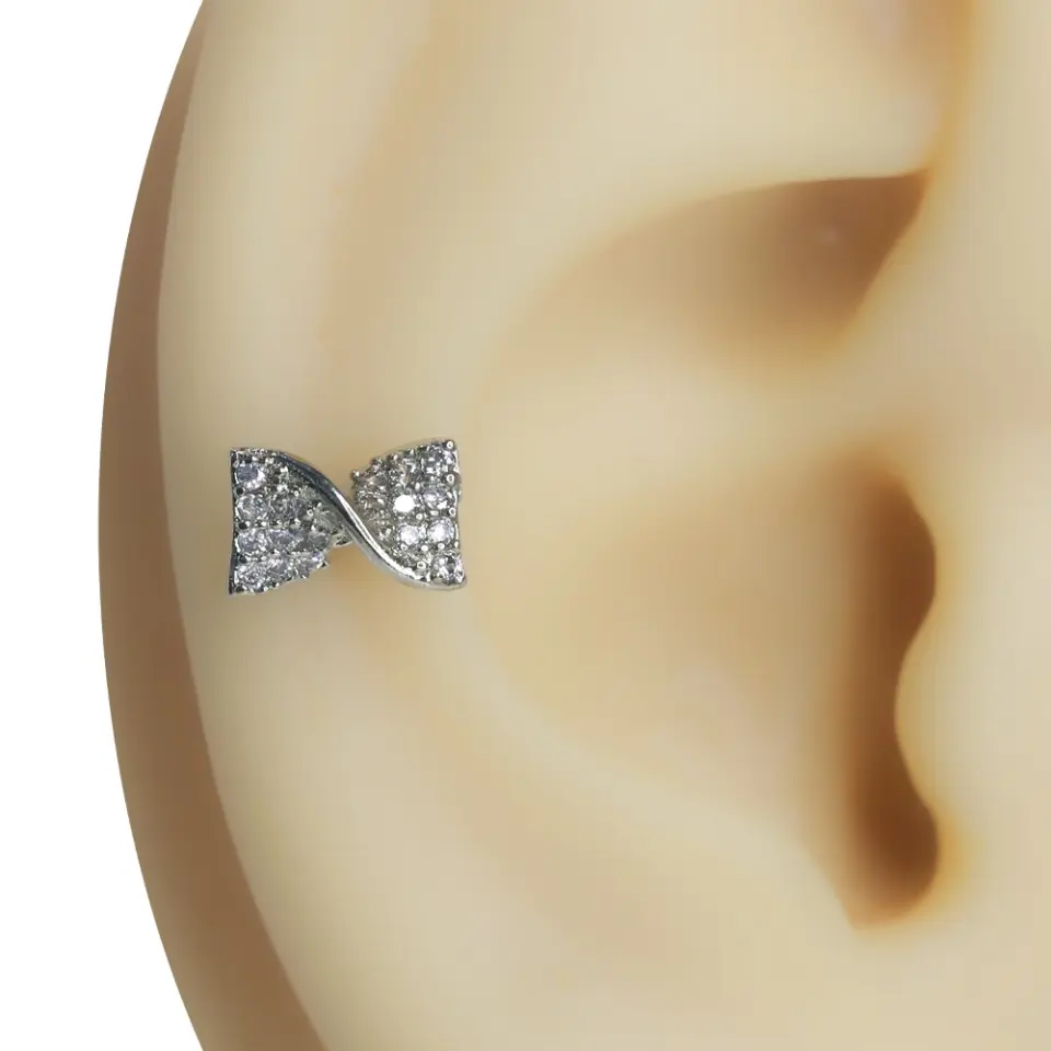 Kulak kıkırdağında parlayan fiyonk formunda zirkon taşlı tragus helix kıkırdak piercing