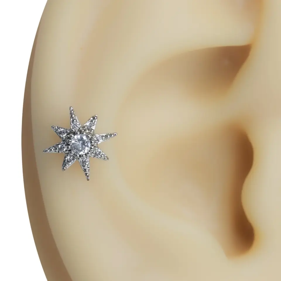 Kulak kıkırdağında sergilenen zirkon taşlı yıldız formunda tragus helix kıkırdak piercing