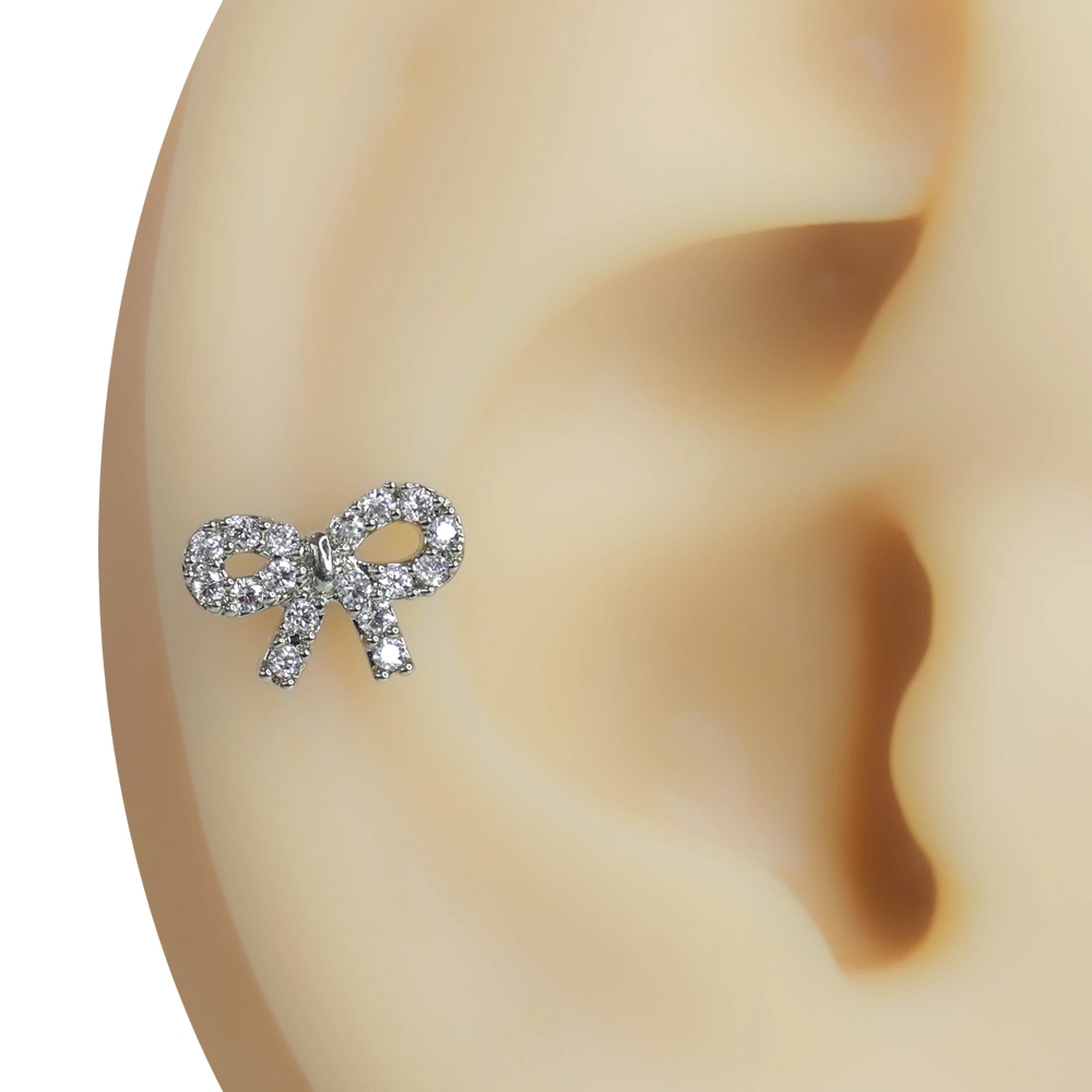 Kulak kıkırdağı üzerinde sergilenen zirkon taşlı fiyonk figürlü tragus helix kıkırdak piercing
