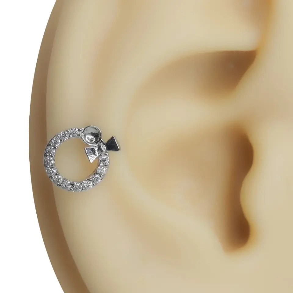 Kulakta duruşu sergilenen zirkon taşlı tragus helix kıkırdak piercing