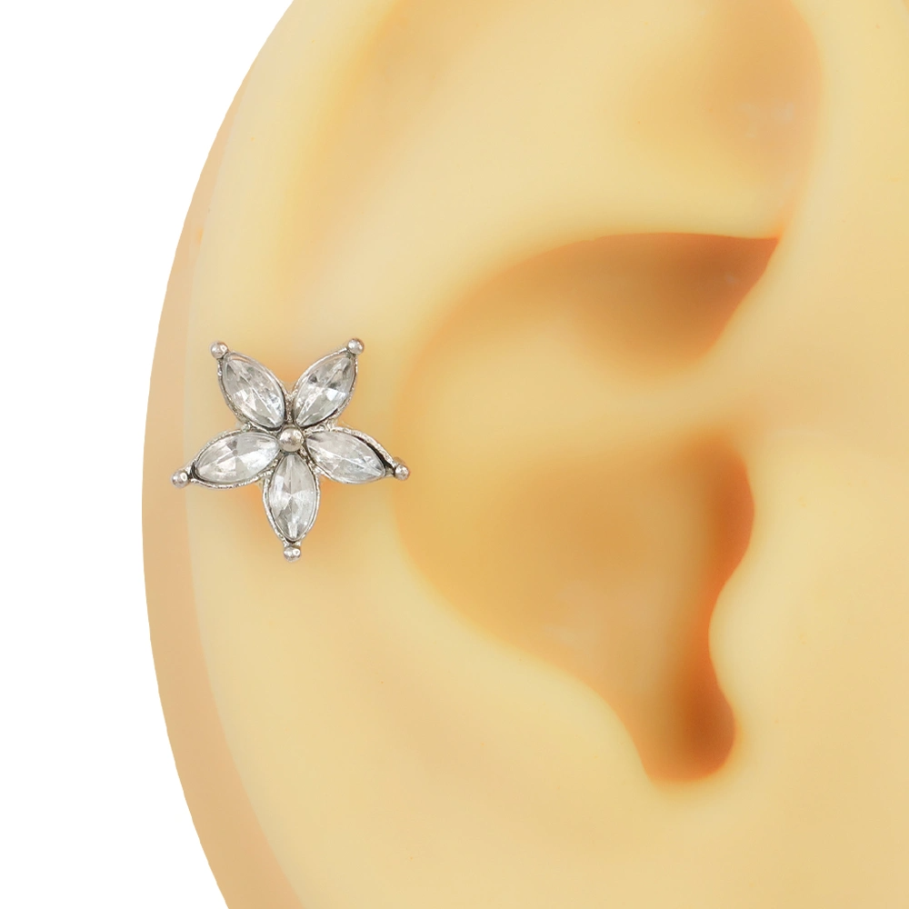 Kulak kıkırdak yapısı üzerinde sergilenen şeffaf mekik kesim taşlı beş yapraklı çiçekli helix piercing