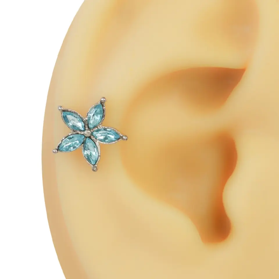 Gümüş tonlu çiçek çerçevesine sahip açık mavi taşlı şık kıkırdak piercing tasarımı.
