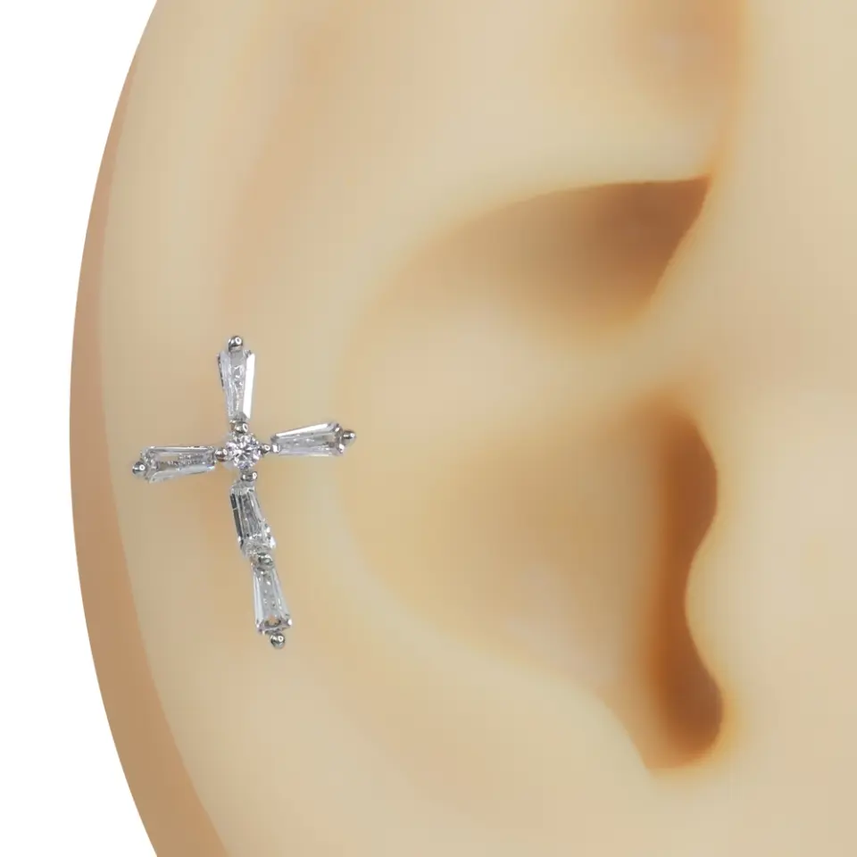 Kulak kıkırdağı bölgesinde takılı baget zirkon taşlı pırıltılı haç tragus helix kıkırdak piercing
