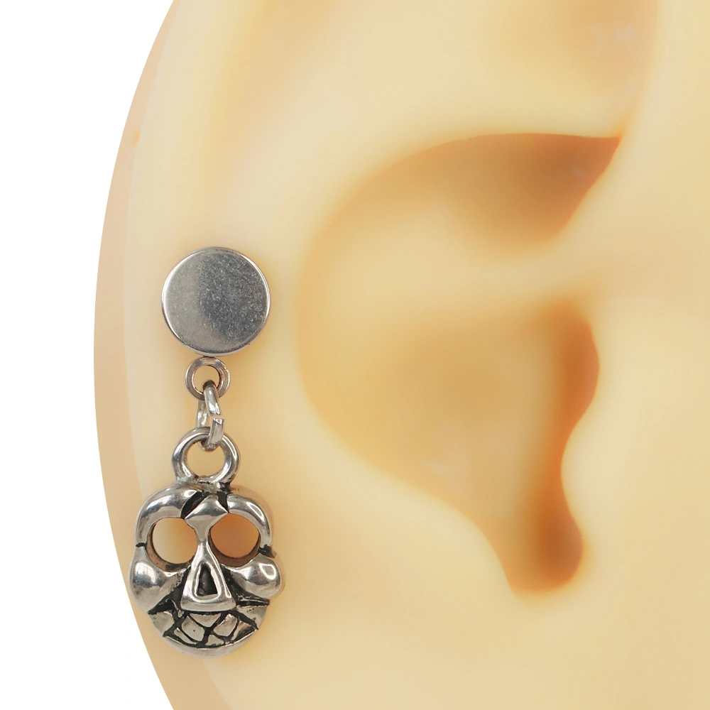Kulak kıkırdak yapısı üzerinde sergilenen gümüş renkli ve taşsız sallantılı kurukafa helix piercing