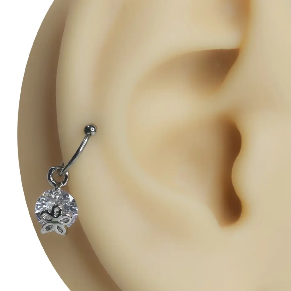 Kulak kıkırdağına takılmış sallantılı papatya figürlü zirkon taşlı tragus helix kıkırdak piercing