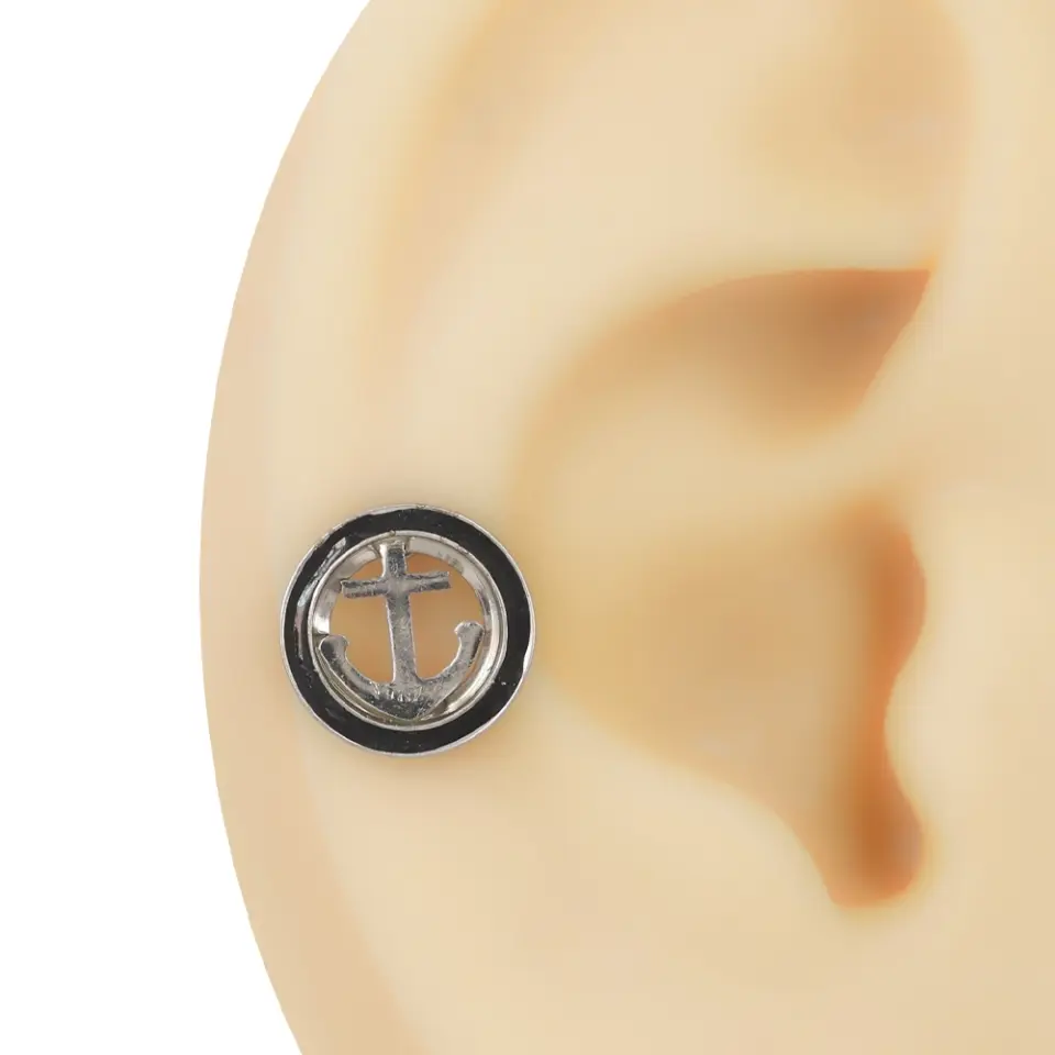 Kulak maketinde sergilenen siyah ve gümüş dairesel çerçeve içinde çapa figürlü tünel görünümlü piercing