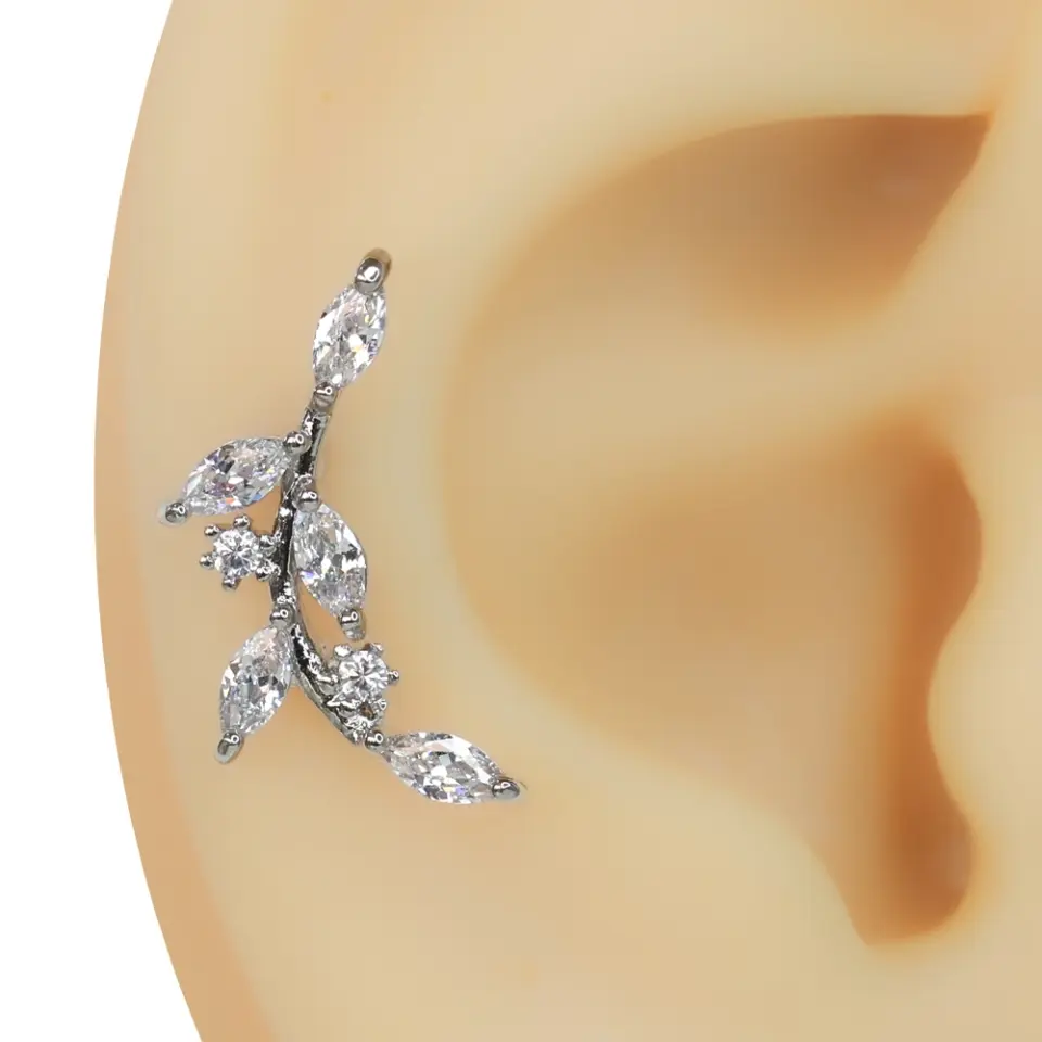 Kulak kıkırdağında bahar dalı formunda duran parlak zirkon taşlı tragus helix kıkırdak piercing