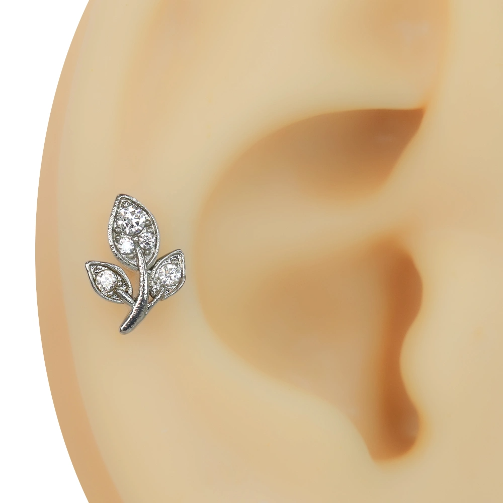 Kulakta sergilenen üç yaprak figürlü zirkon taşlı tragus helix kıkırdak piercing modeli