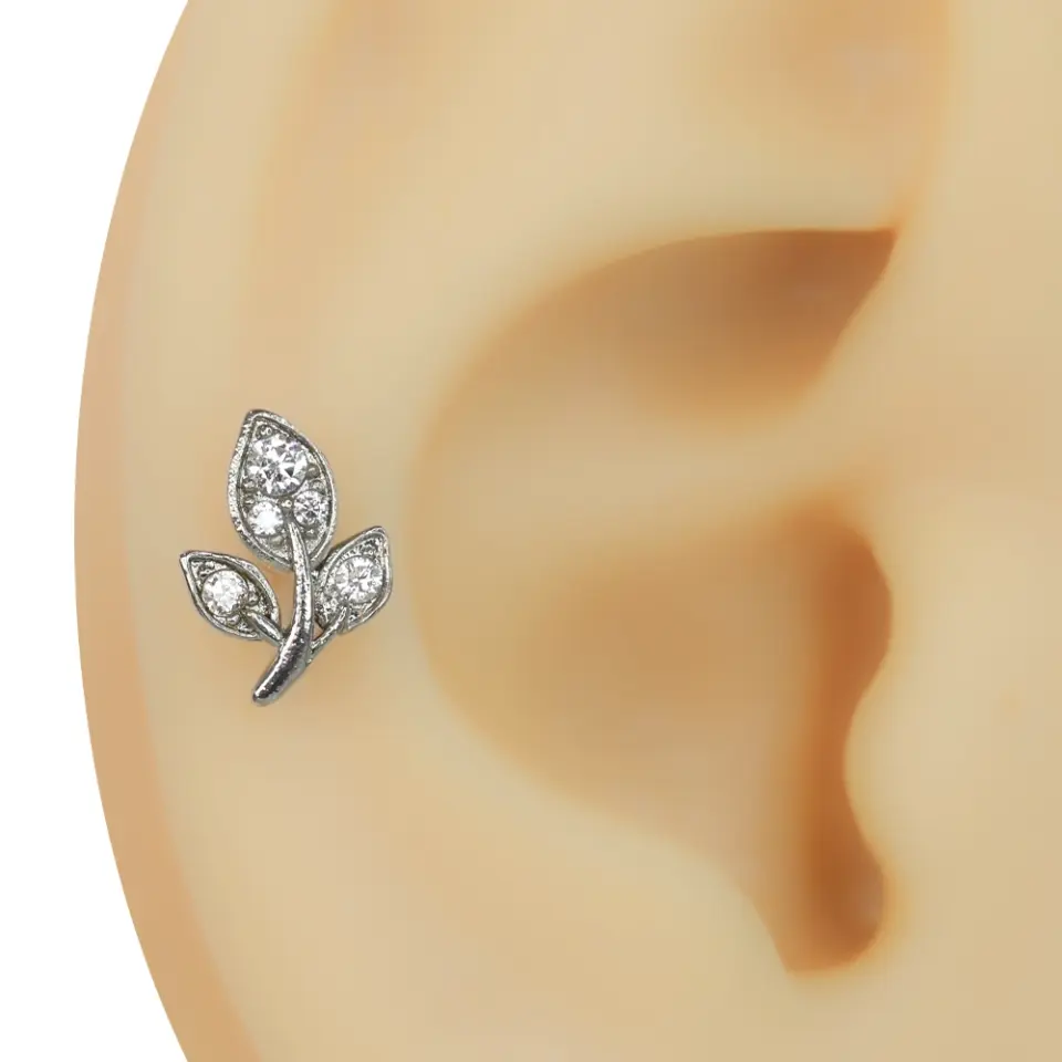 Kulakta sergilenen üç yaprak figürlü zirkon taşlı tragus helix kıkırdak piercing modeli