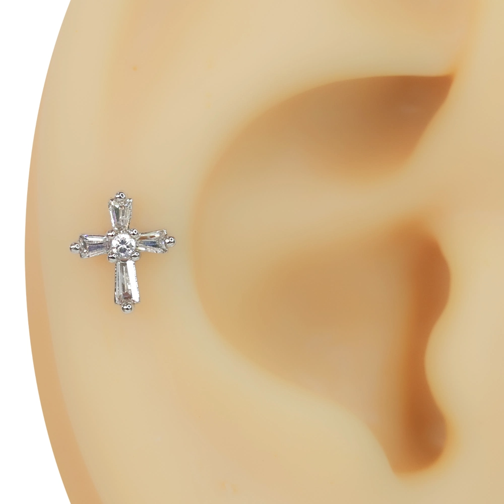 Kulak kıkırdağında sergilenen zirkon taşlı haç figürlü tragus helix kıkırdak piercing