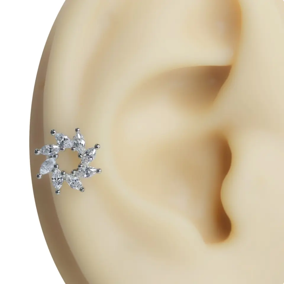 Kulak kıkırdağında sergilenen güneş formlu zirkon taşlı tragus helix kıkırdak piercing
