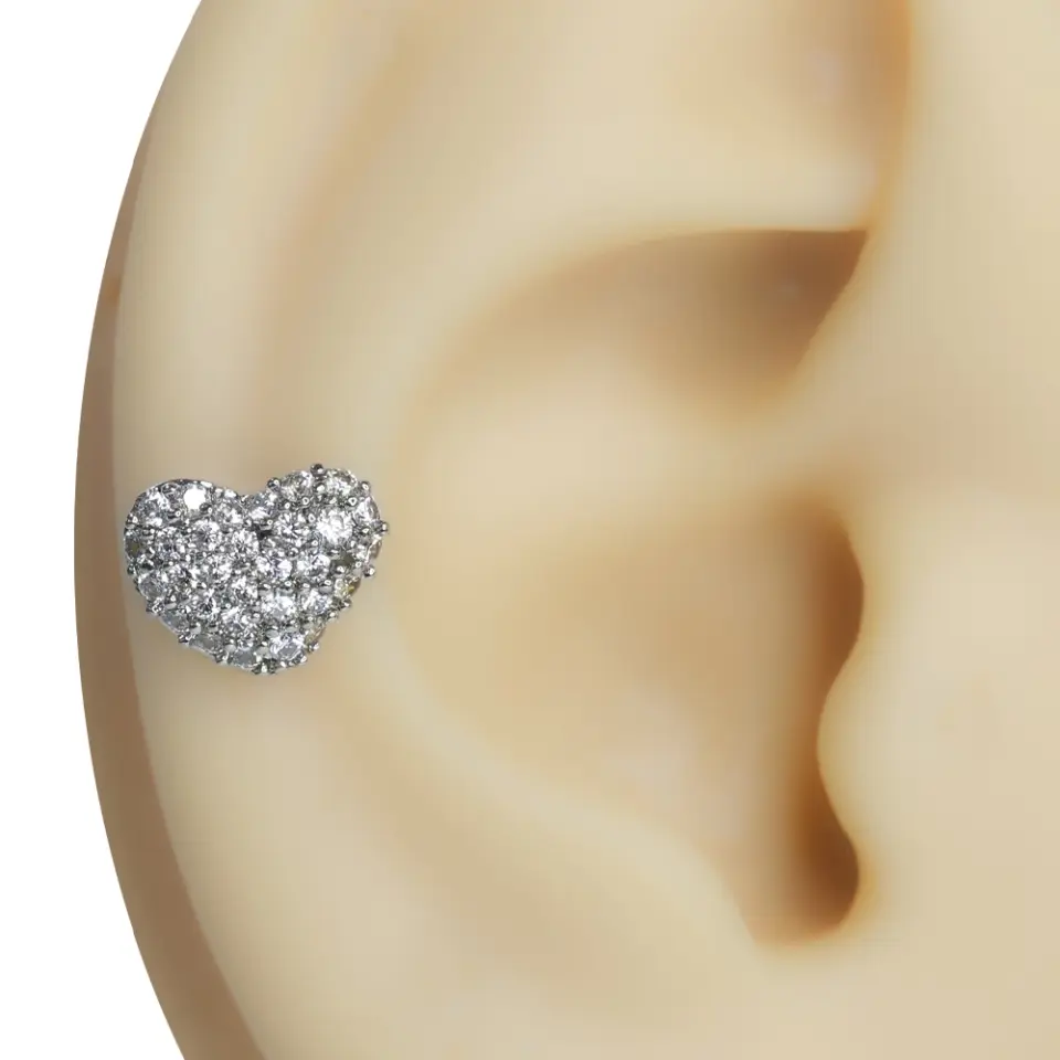 Kulak üzerinde sergilenen gümüş renkli aşık kalp formunda zirkon taşlı tragus helix kıkırdak piercing