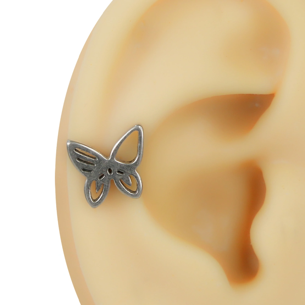Kulakta helix bölgesinde takılı gümüş renkli içi boş kelebek figürlü flatback piercing