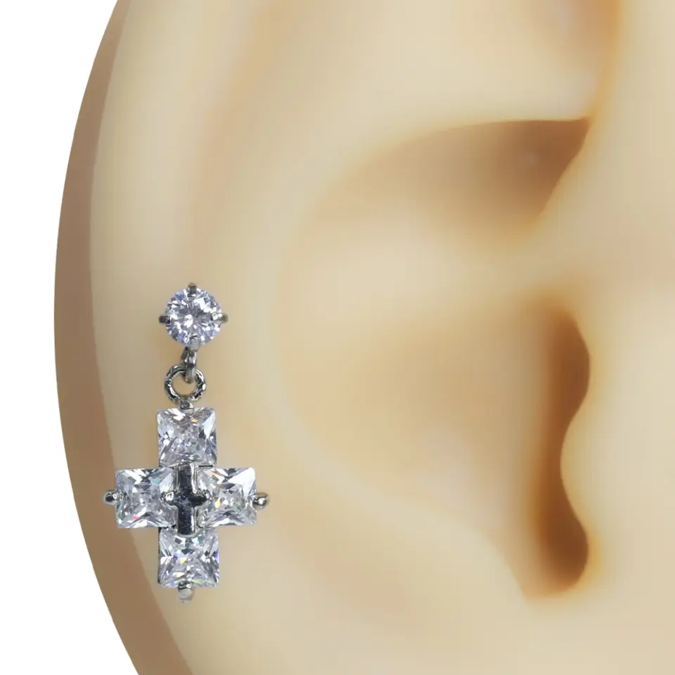 Kulak üzerinde sergilenen gümüş renkli haç figürlü zirkon taşlı tragus helix kıkırdak piercing