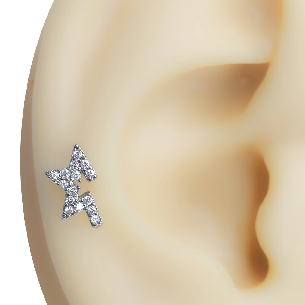 Kulak kıkırdak bölgesinde sergilenen zirkon taşlı yıldız figürlü tragus helix kıkırdak piercing