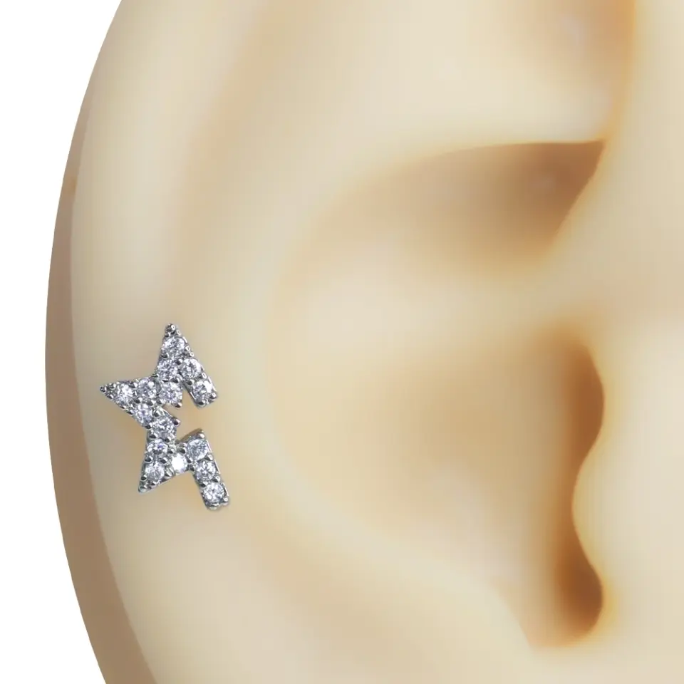 Kulak kıkırdak bölgesinde sergilenen zirkon taşlı yıldız figürlü tragus helix kıkırdak piercing