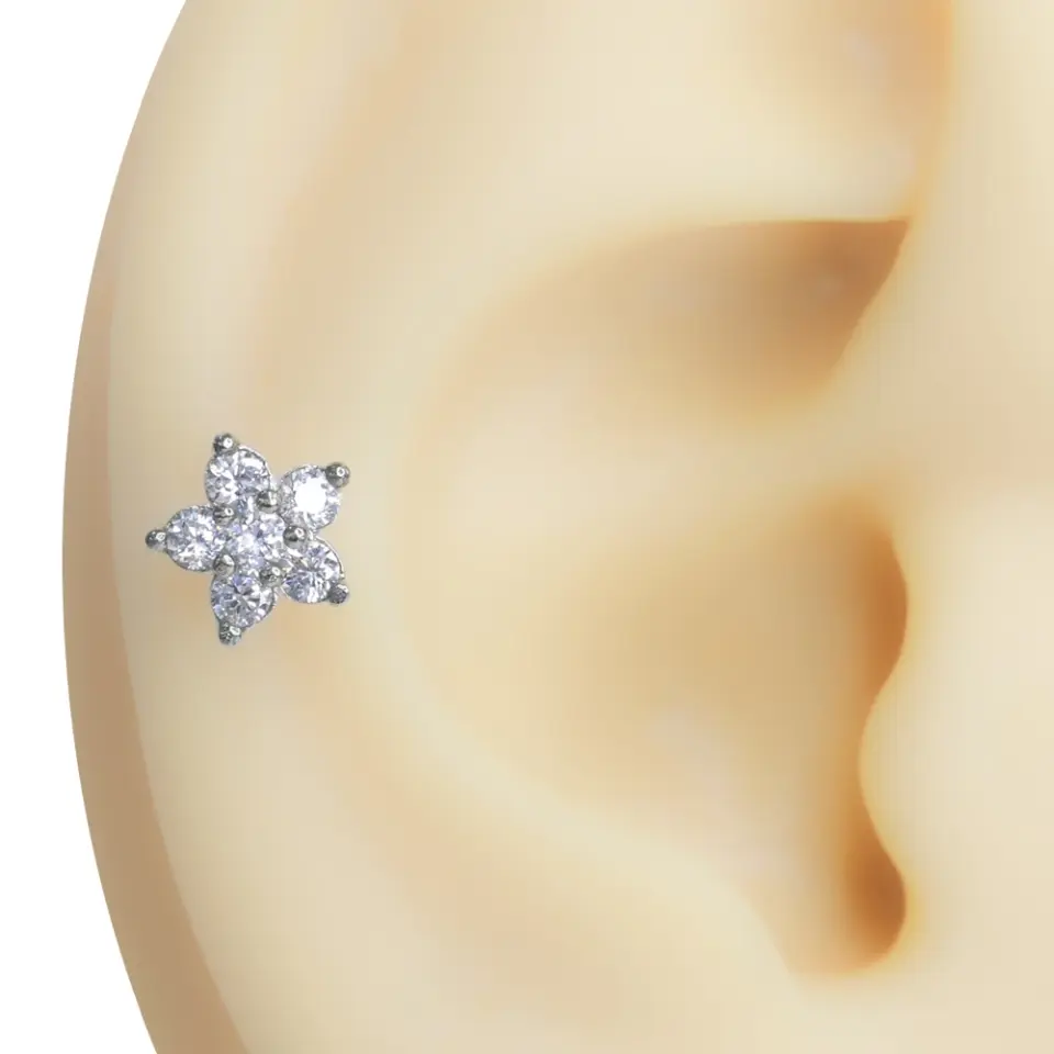 Kulak kıkırdağında sergilenen zirkon taşlı çiçek figürlü tragus helix kıkırdak piercing