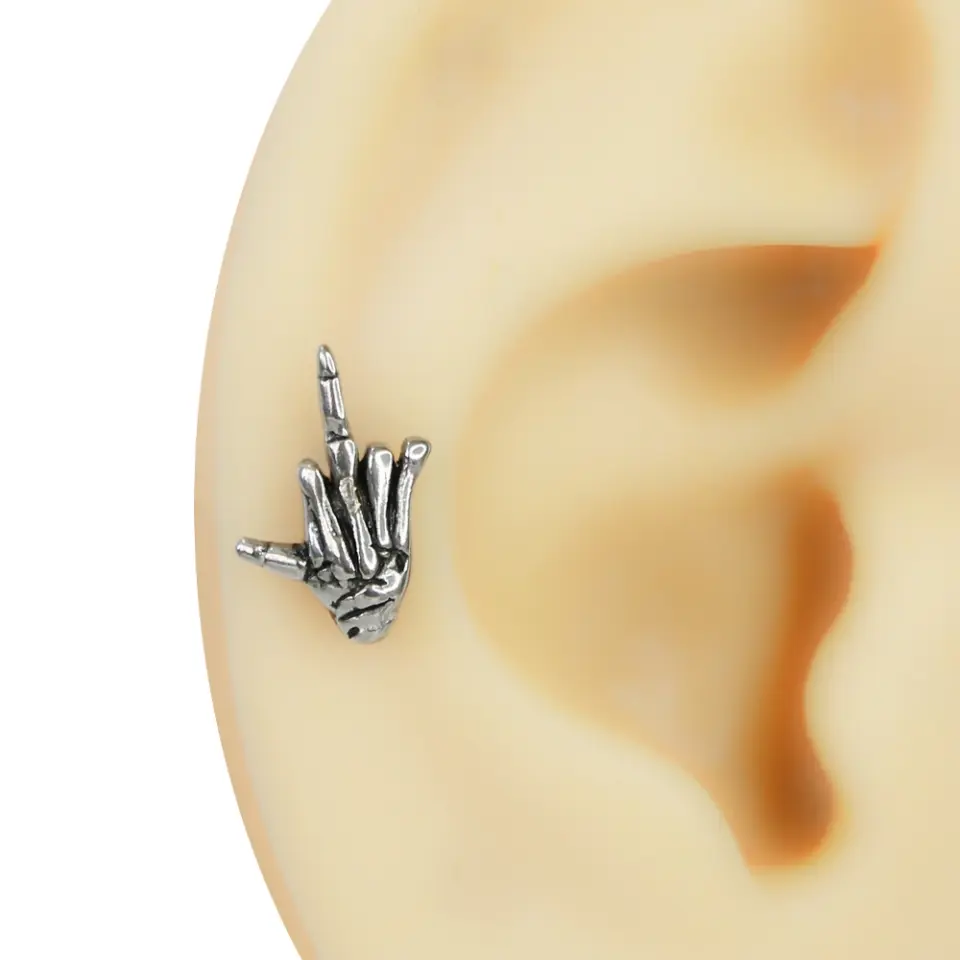 Gümüş renkli, işaret ve serçe parmağı yukarıda olan rock el işareti formundaki iskelet eli kulak piercingi