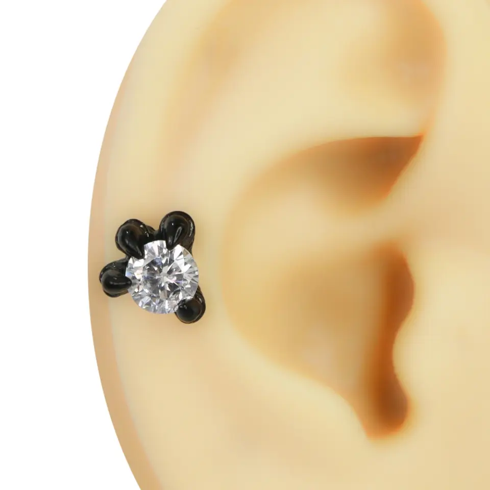 Kulak kıkırdak bölgesinde sergilenen dört pençeli şeffaf taşlı siyah helix piercing
