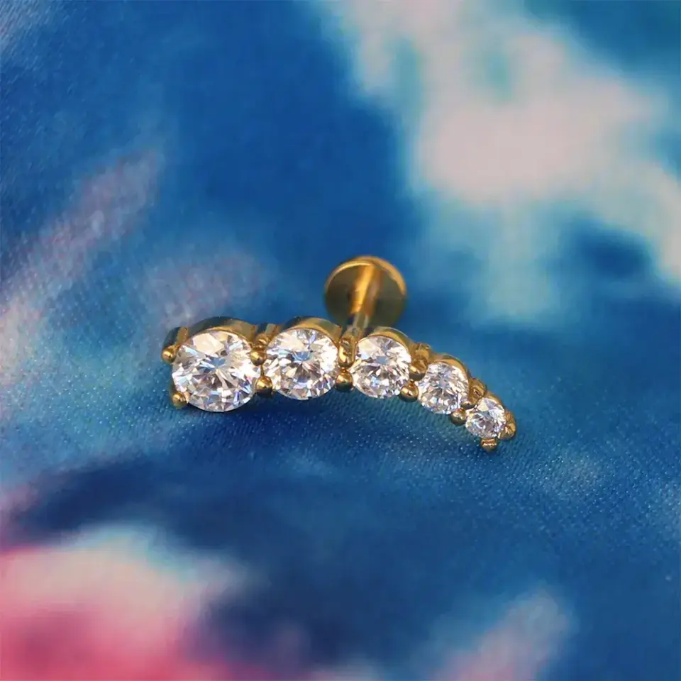 Altın sarısı diagonal dizilimli beş taşlı kıkırdak küpesi helix ve tragus uyumlu